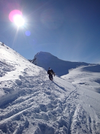 © Simon Welebil Stephan Kondert mit dem Snowboard unterm Arm beim Hiken zur nächsten Abfahrt
